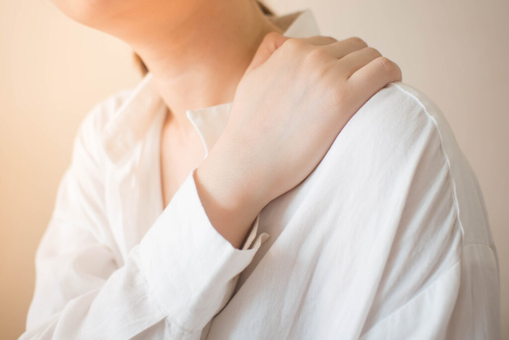 Vrouw met frozen shoulder voelt haar schouder