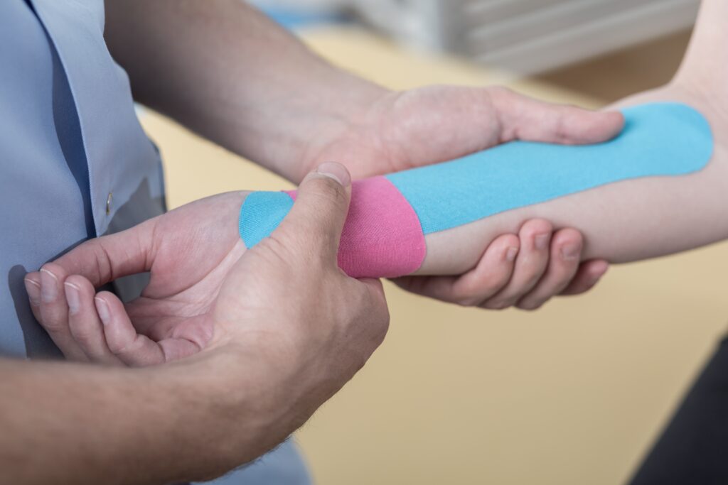Instabiele pols wordt ondersteund door kinesio tape door fysiotherapeut