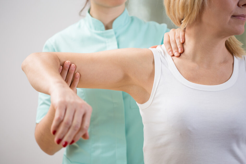 Vrouw met schouderklachten krijgt behandeling van fysiotherapeut